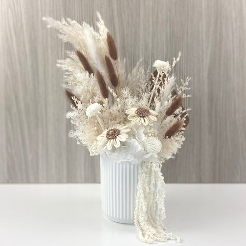 Dried and preserved everlasting floral arrangement with chocolate and white flowers in a ceramic vase 